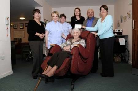 Hospice patient Iris Pack relaxes in one of the new chairs surrounded by staff and Mahmoud and Maggie Boutorabi