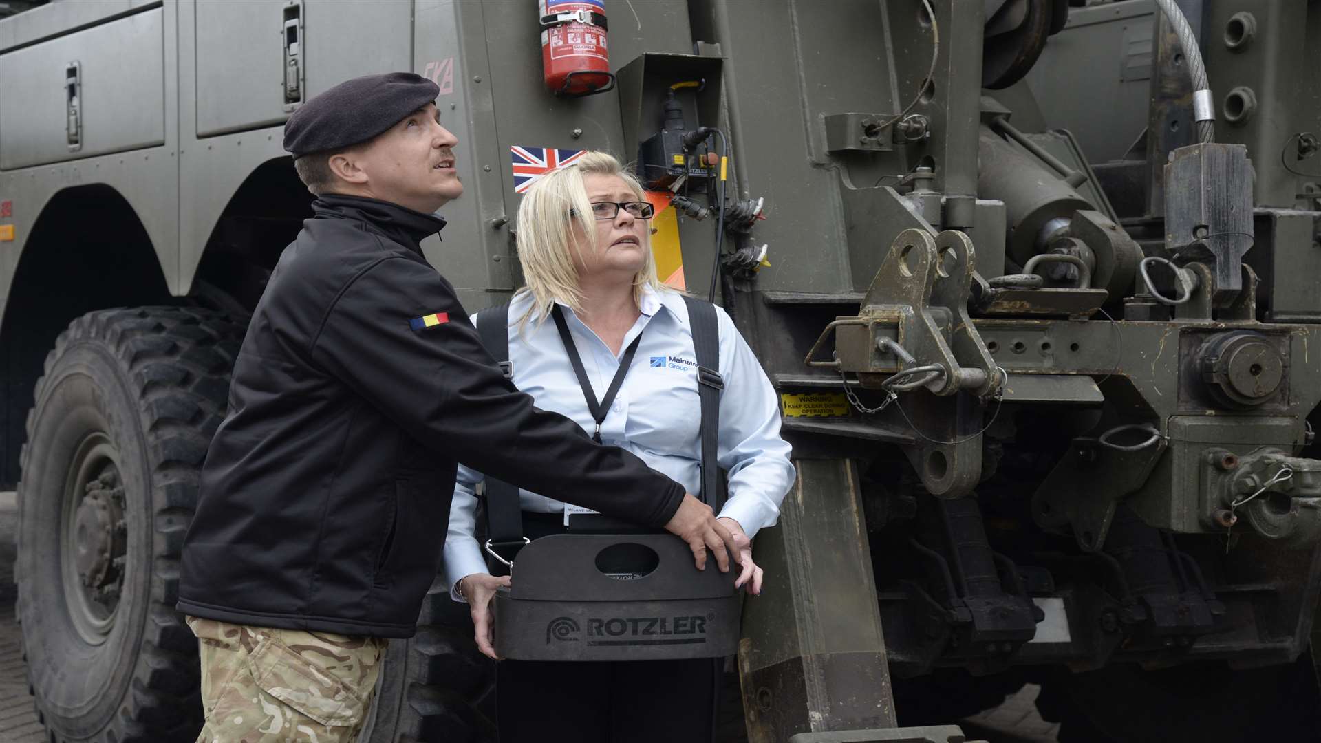 L Cpl James Hamilton of the Royal Electrical and Mechanical Engineers coaches Mainstream's Melanie Baker on the controls of an army recovery vehicle during the open day