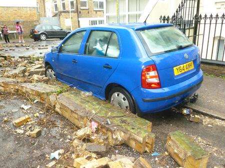 Car surrounding by fallen wall after flash floods in Margate.