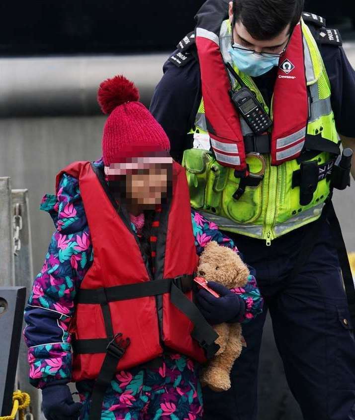 A young girl was seen clutching a teddy bear as she arrived in Dover today. Picture: (Gareth Fuller/PA)