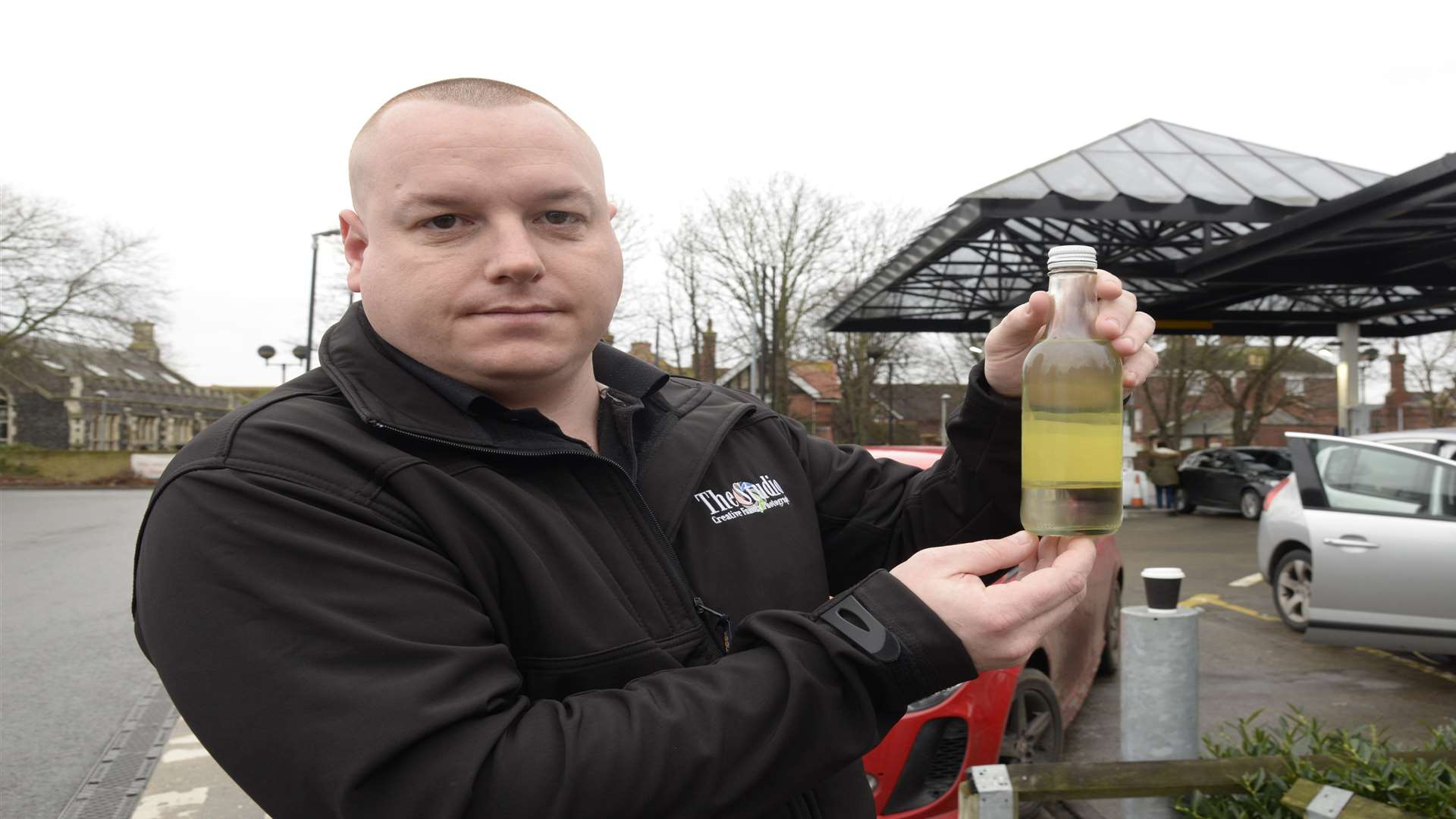 Daniel Peters with a sample of the contaminated petrol purchased at Tesco's Faversham filling station. Picture: Chris Davey