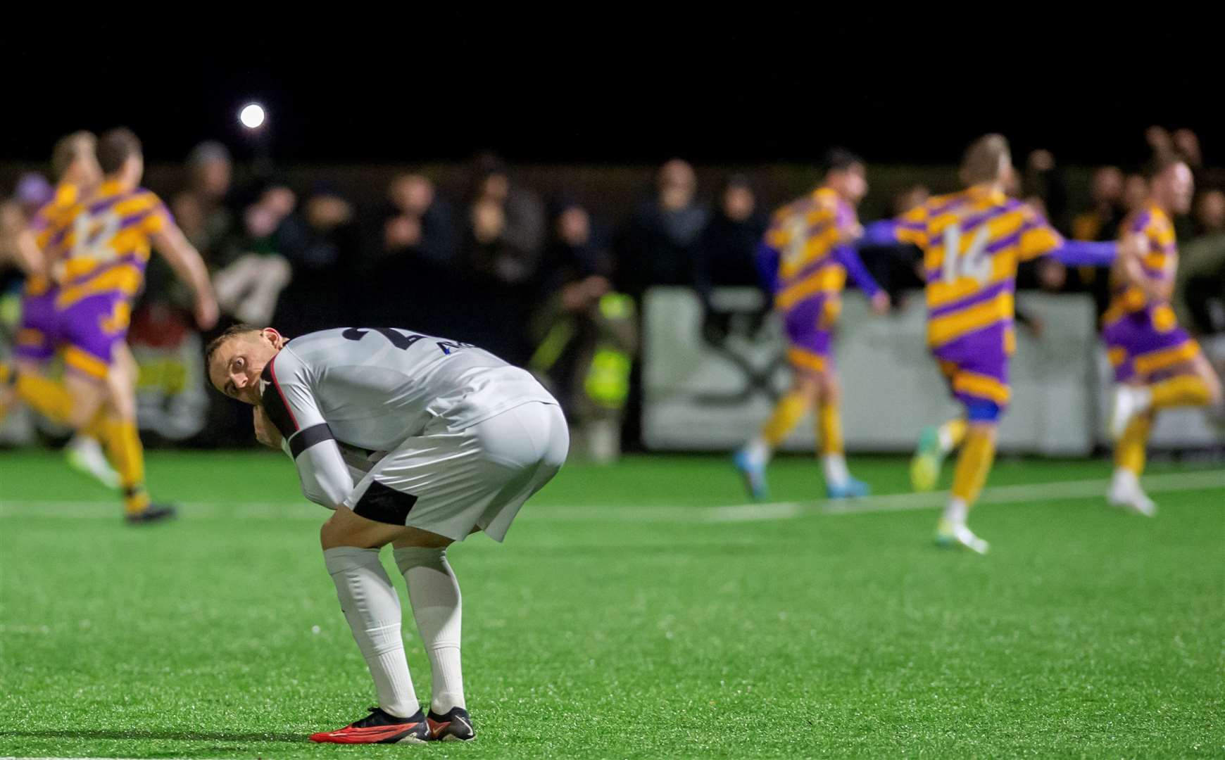 Faversham’s Matt Parsons cuts a dejected figure as Deal celebrate in what turned out to be Sammy Moore’s final match in charge of the Lilywhites. Picture: Ian Scammell