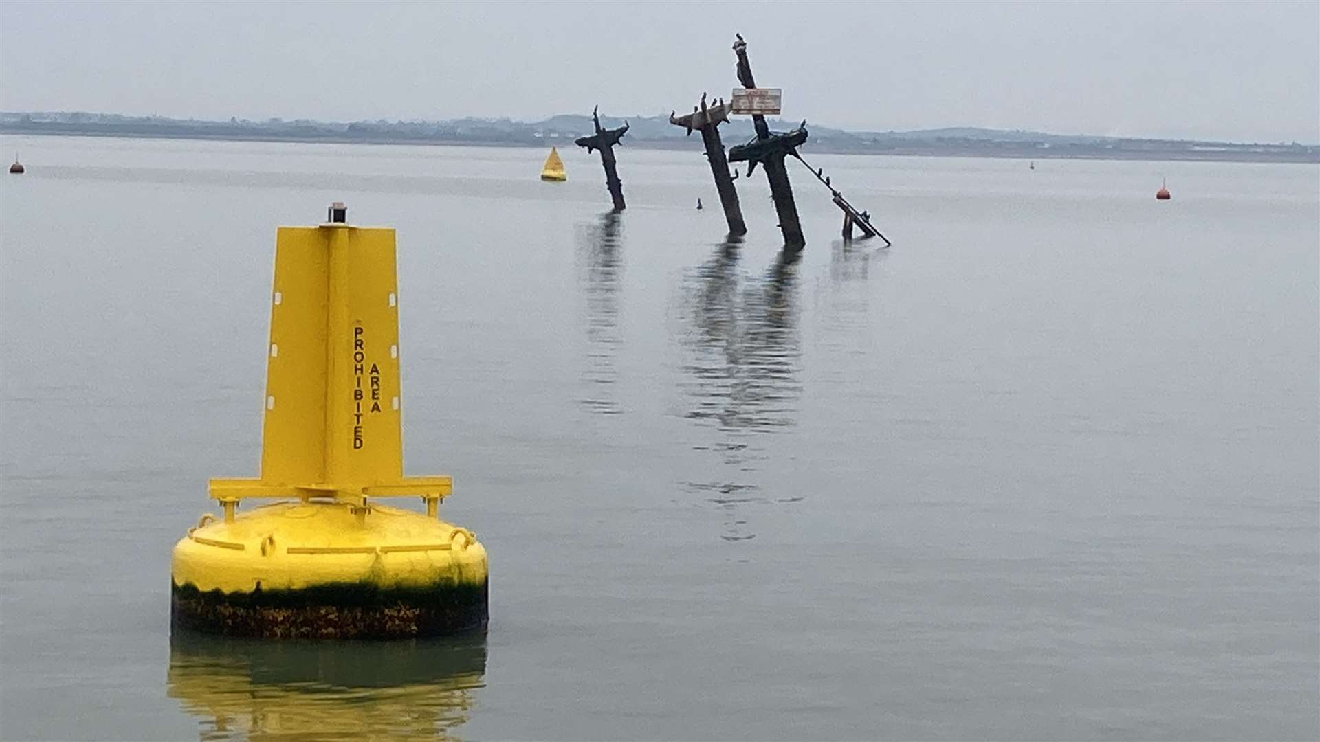 The ghostly masts and yellow marker buoy of Sheppey bomb ship SS Richard Montgomery as seen from the X-Pilot