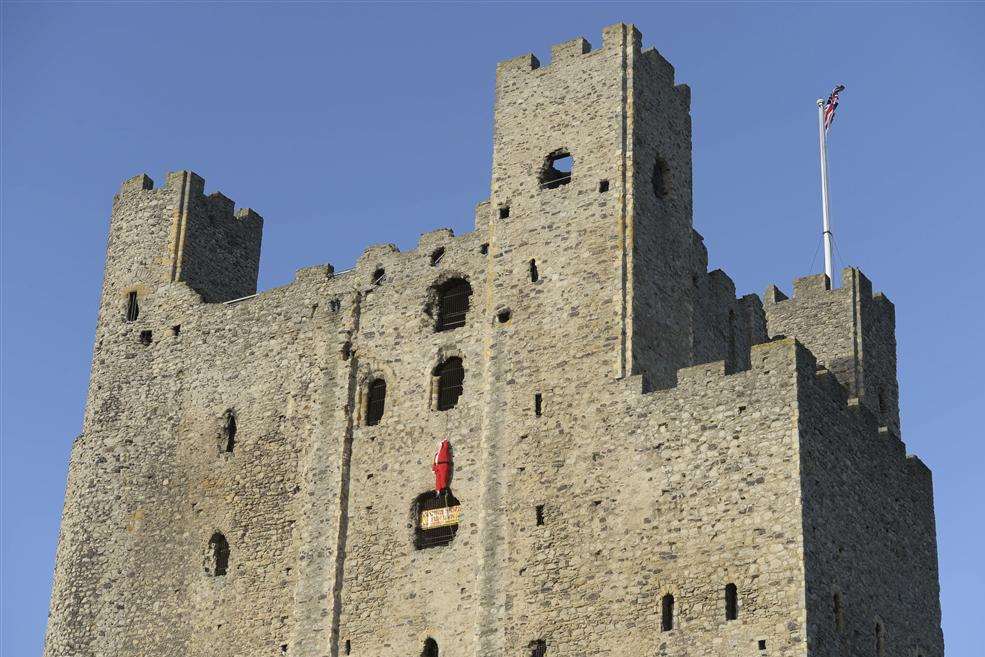 A full-sized Santa Claus figure hangs from a window of Rochester Castle