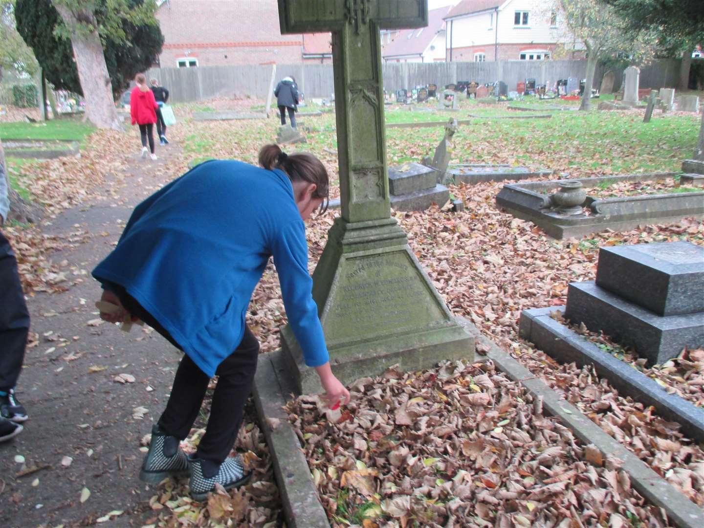 Imogen Perriman, 10, of Halfway Houses Primary School lays a poppy cross on a war grave at Halfway cemetery