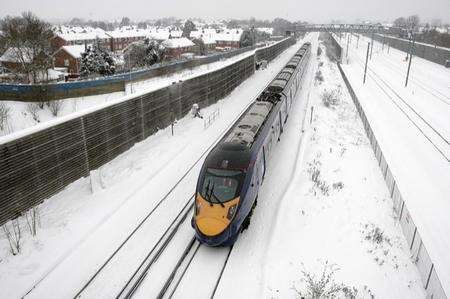 A high speed train manages to head towards Folkestone from Ashford. Ashford continues under a blanket of snow.