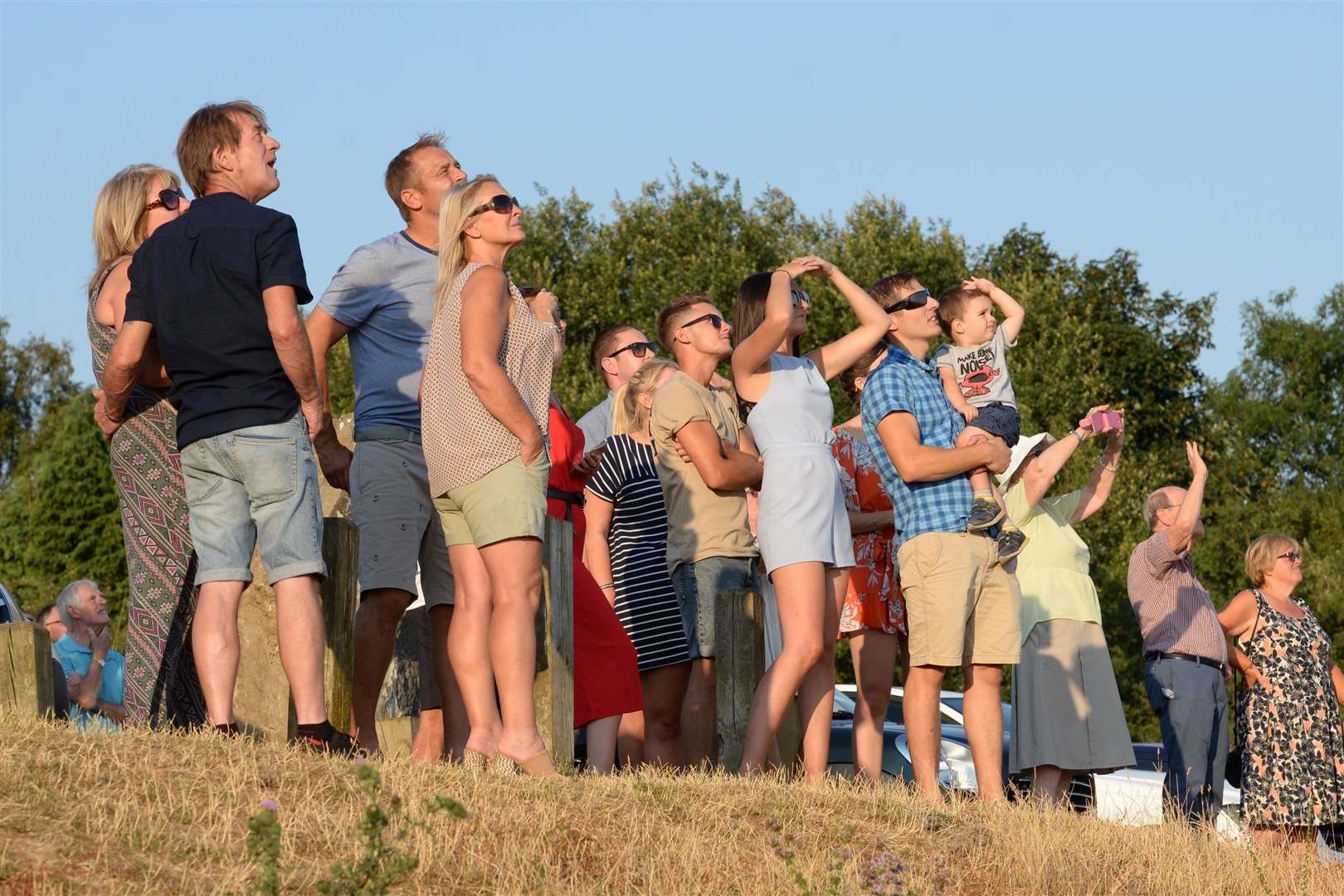 Relatives, friends and colleagues watch the present air ambulance perform a fly-past over the memorial to the air ambulance crew who crashed 20-years ago at Bluebell Hill on Thursday. Picture: Chris Davey. (3303943)