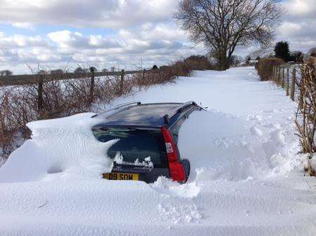 Cars were buried by snow drifts in a country lane in Elham today