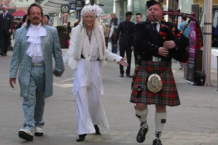 Piper Ivan Brooks, Sgt of the City of Rochester Pipe Band, walks the couple back through the shopping centre