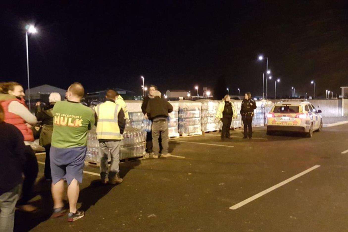 People queuing for bottles of water last night as their supply remained cut off