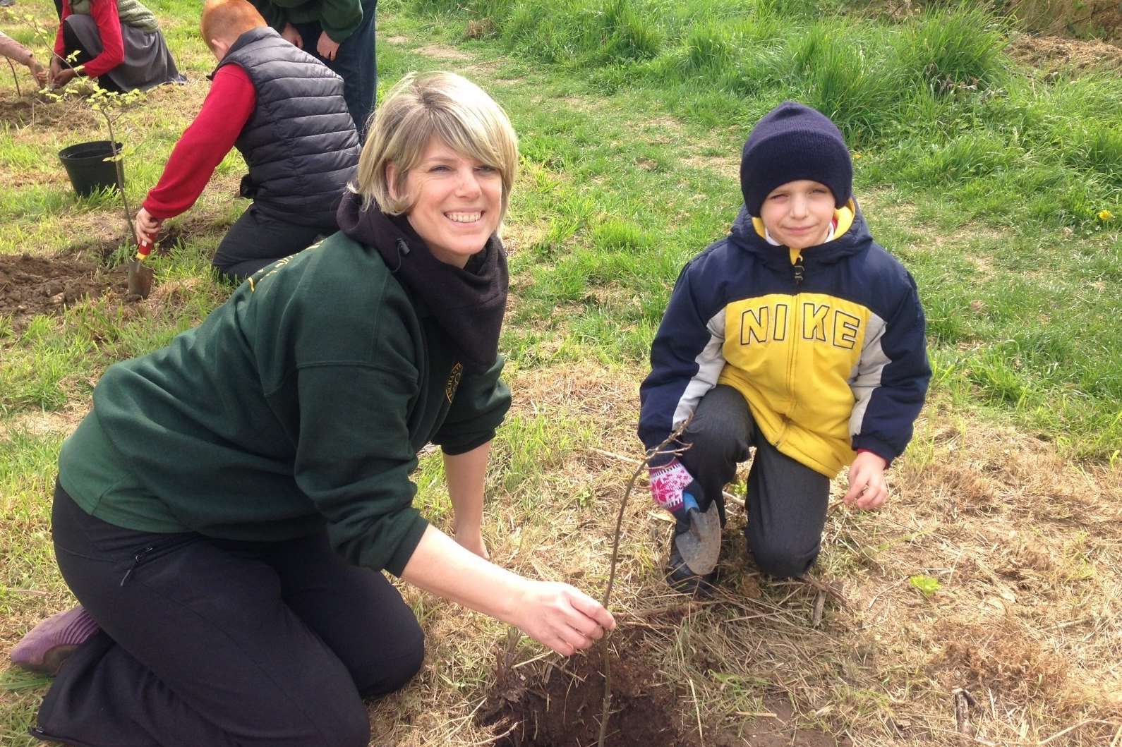 Teacher Louise Neaves and pupil Kajus plant one of the trees