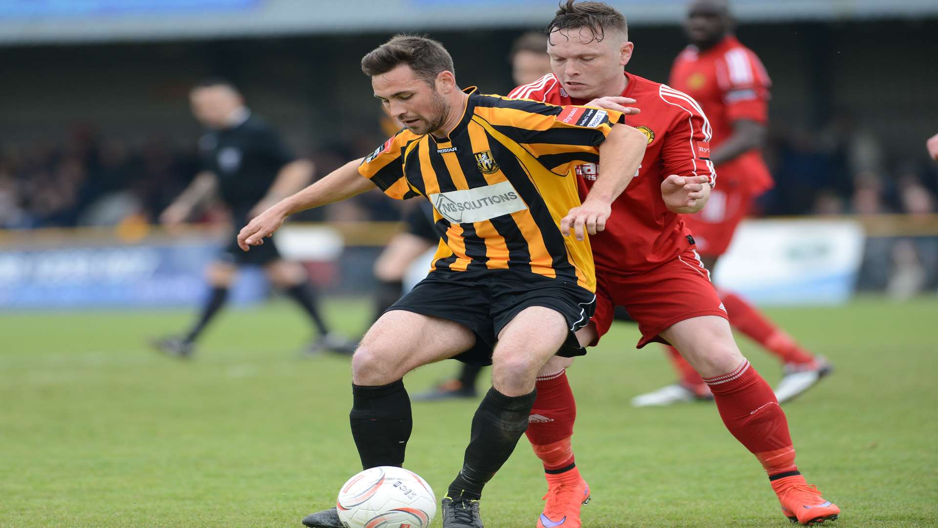 Ronnie Dolan holds off Merstham striker Tommy Hutchings Picture: Gary Browne