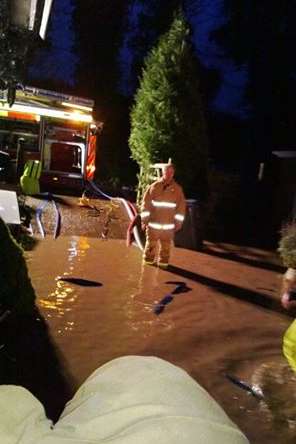 Firefighters pumping water from a home in Studdal