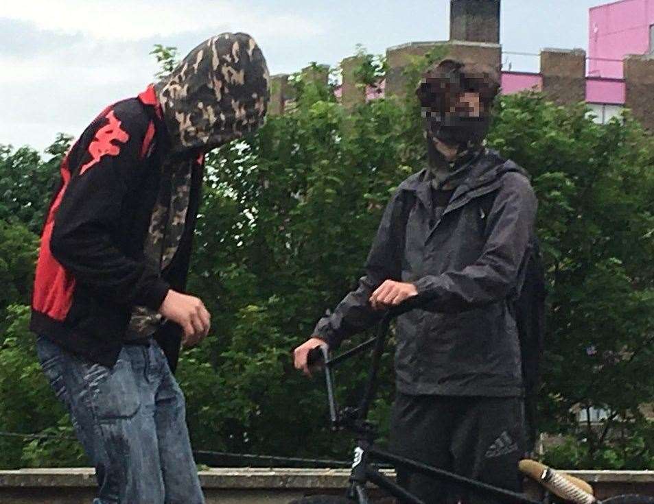 A masked and hooded boy putting themselves in danger