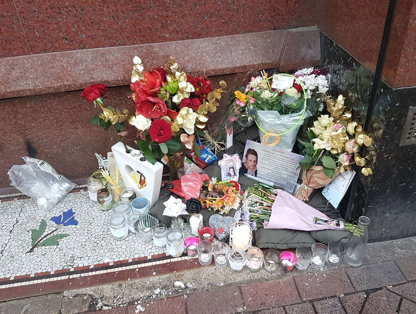 An eye-catching display of candles and flowers has been left outside NatWest