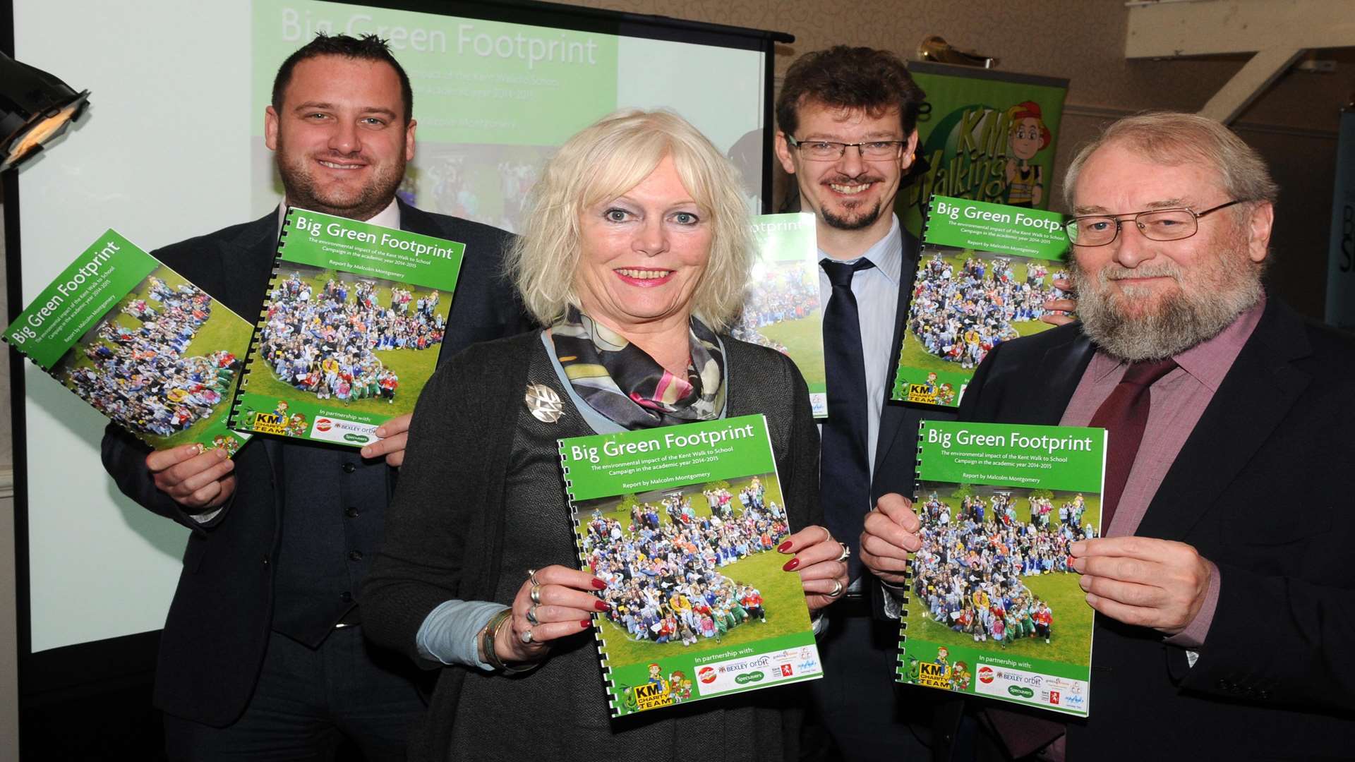 Matt Trusty of Specsavers, Craig Atkins of Orbit South and KM Charity Team trustees Gill Delahunty and Stuart Smith showcase the Big Green Footprint report at the KM Walk to School Awards presentation at Rowhill Grange, Wilmington