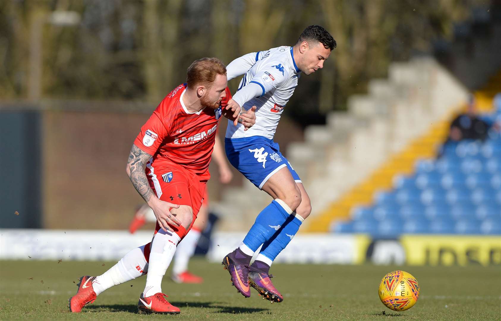 Gillingham’s Connor Ogilvie challenges with Bury's Zeli Ismail at Gigg Lane