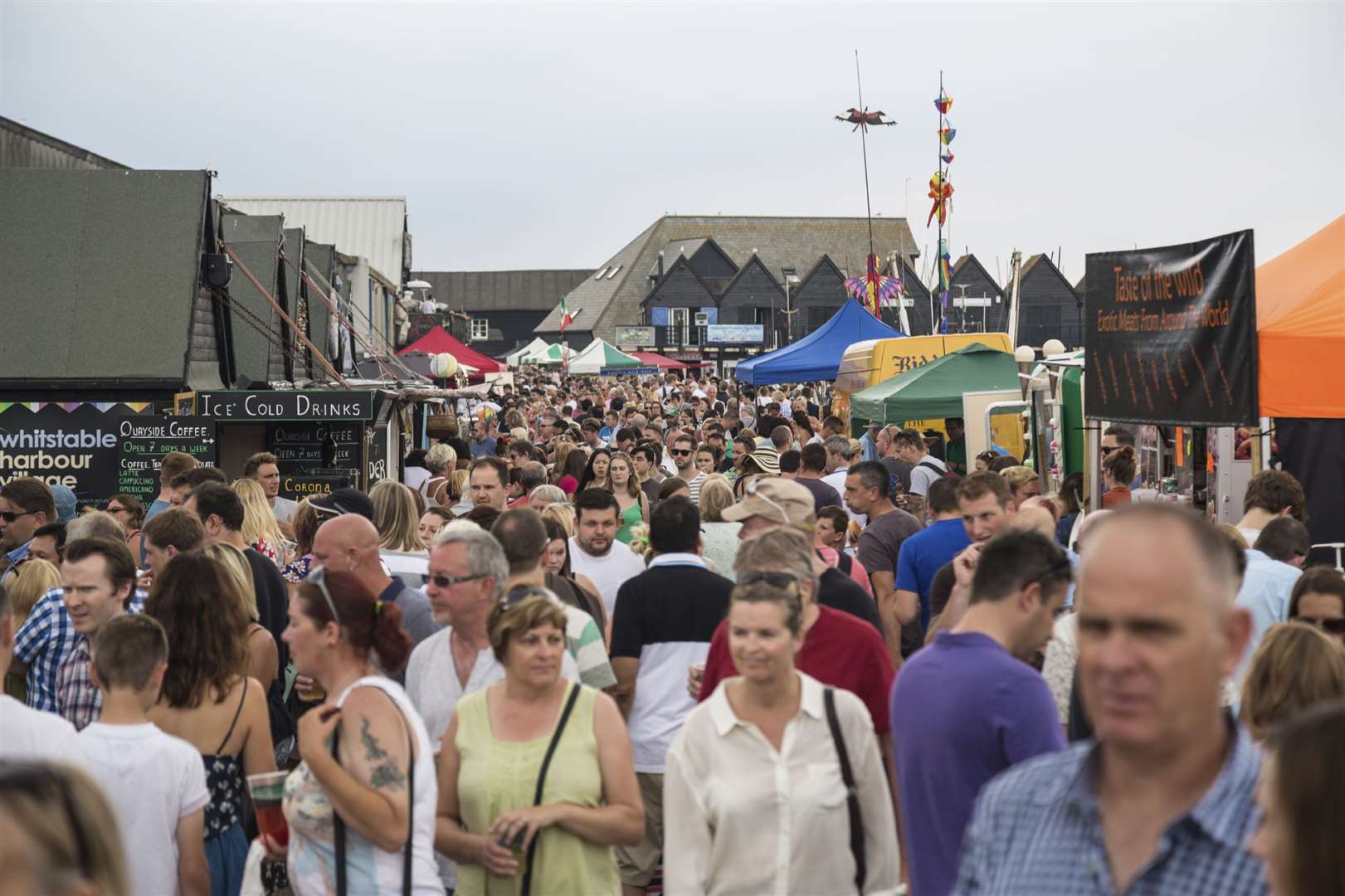 Crowds of tourists and locals fill the harbour enjoying the quaint stalls during Whitstable Oyster Festival