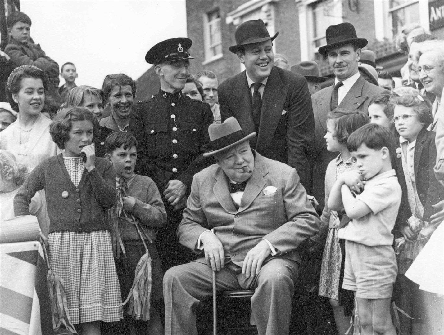 Winston Churchill pictured at the annual carnival procession at Westerham in June 1954. His son-in-law Christopher Soames is standing behind his chair
