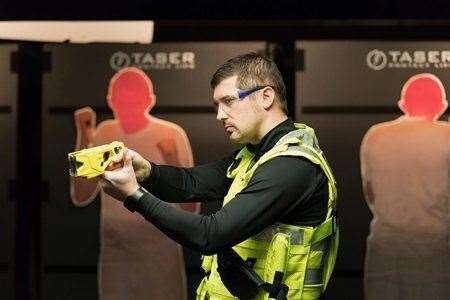 An officer demonstrates the new Taser. Photo: Martin Birks