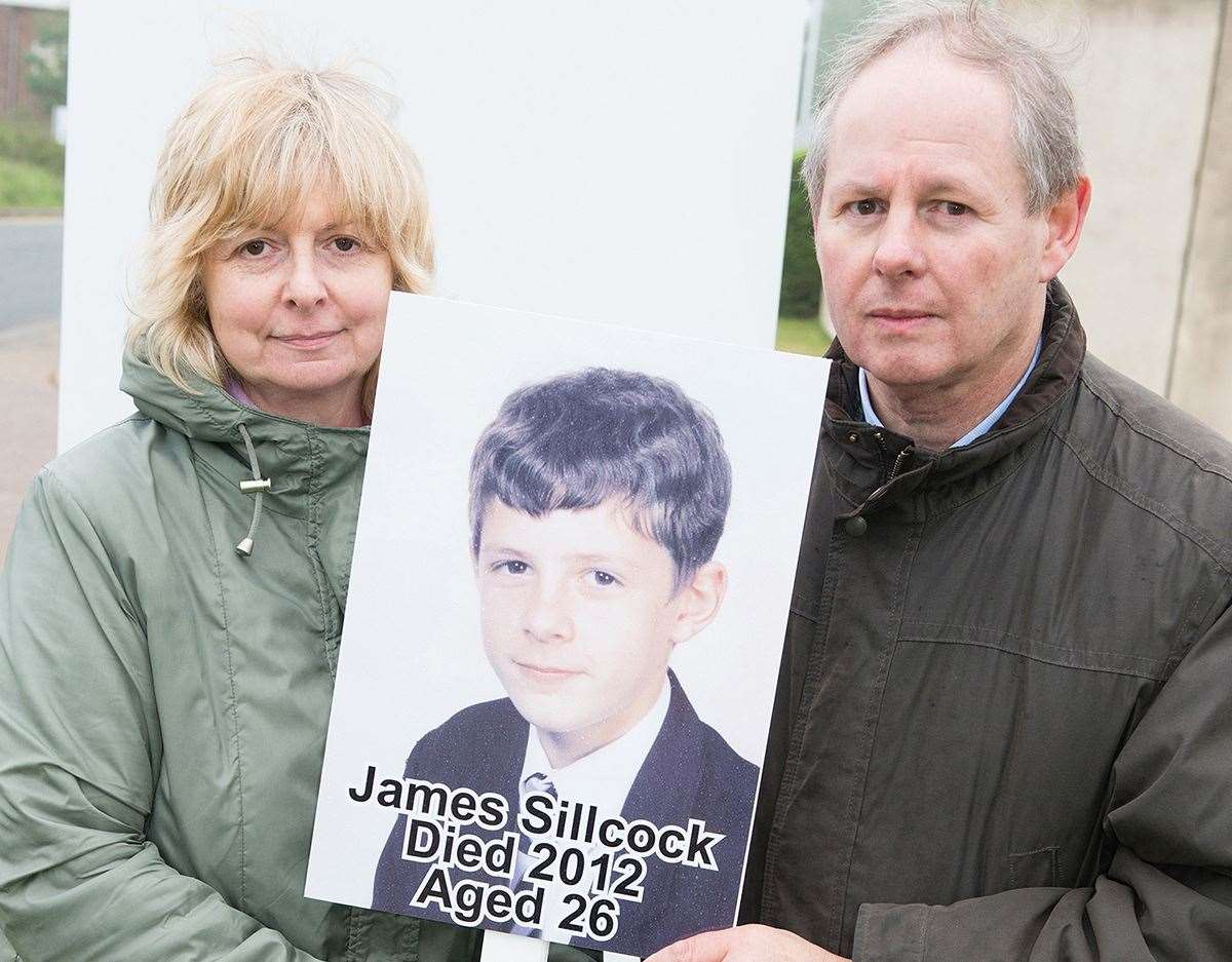Lorraine and Melvin Sillcock holding a placard and photo of son James who committed suicide after taking acne drug Roaccutane. Picture: Melvin Sillcock
