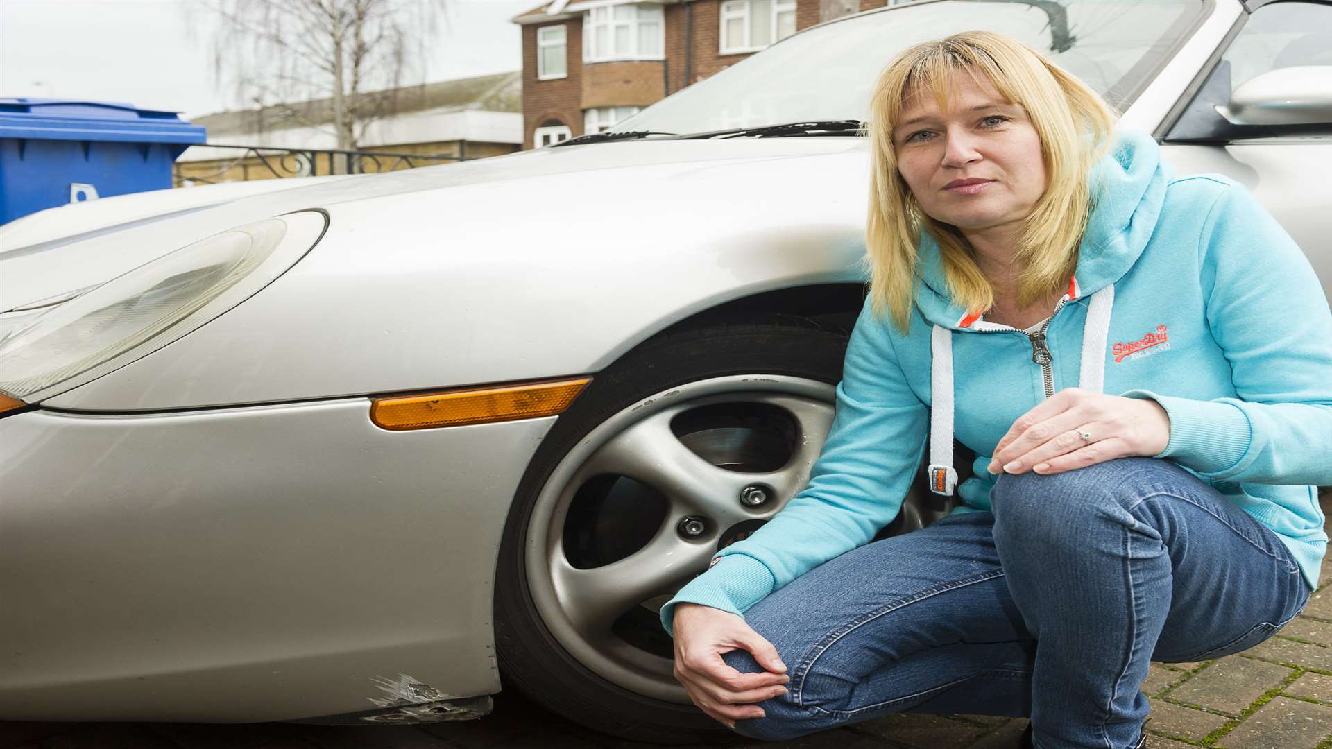 Helen Davy with the family's 1997 Porsche Boxter, damaged by a brick thrown by youths.