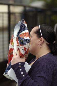Michelle Roberts, who stole money from charity tins, hides her face as she leaves court