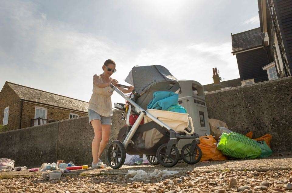 A lady pushes her pram through the litter and debris discarded in Whitstable photo: Tim Stubbings