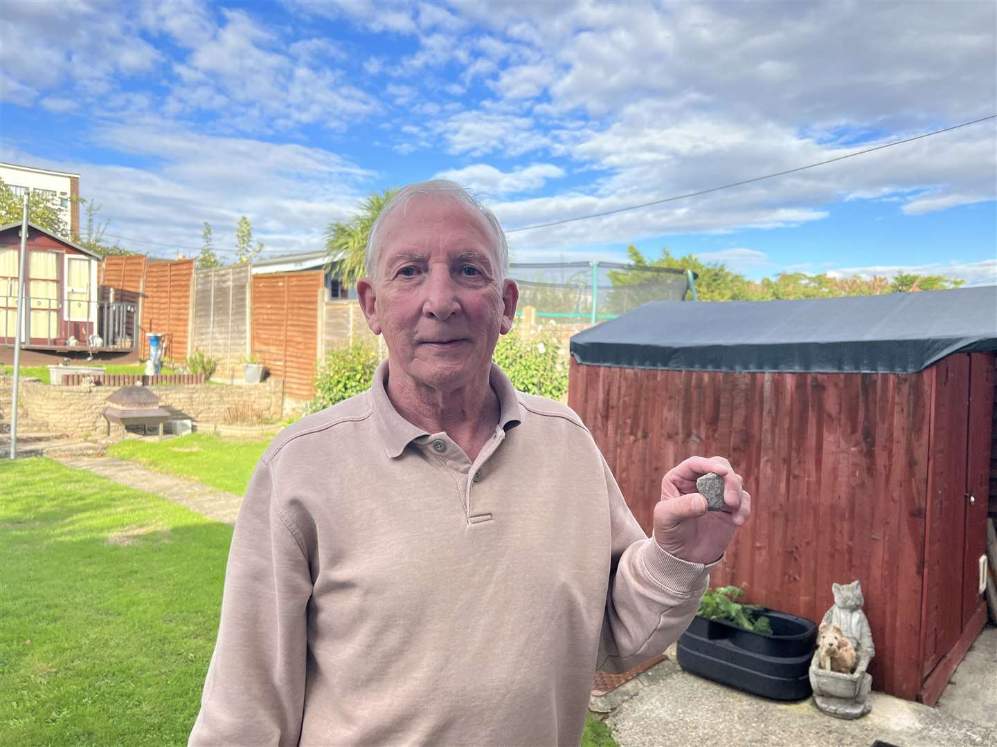 Terrence Glover, 73, holding the stone that hit his Coombe Drive home