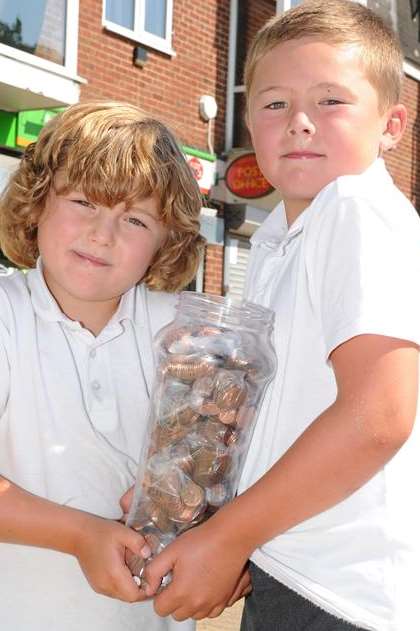 Caleb and Toby Mitchell, seven and nine, with their money jar