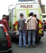 The men are bundled into the back of a police van
