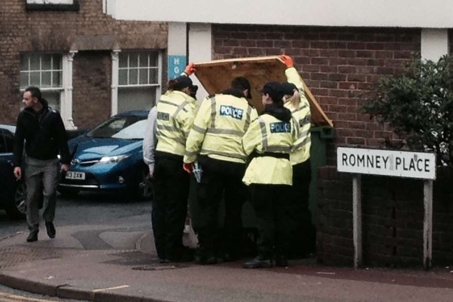 Police search a commercial bin near the scene