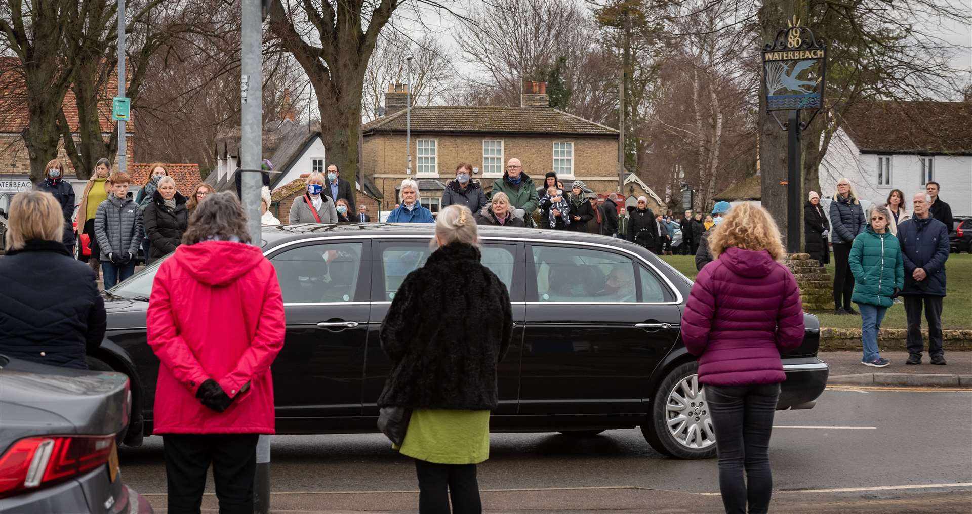 Mourners show their respects as a funeral procession passes by in Waterbeach. Picture: Keith Heppell