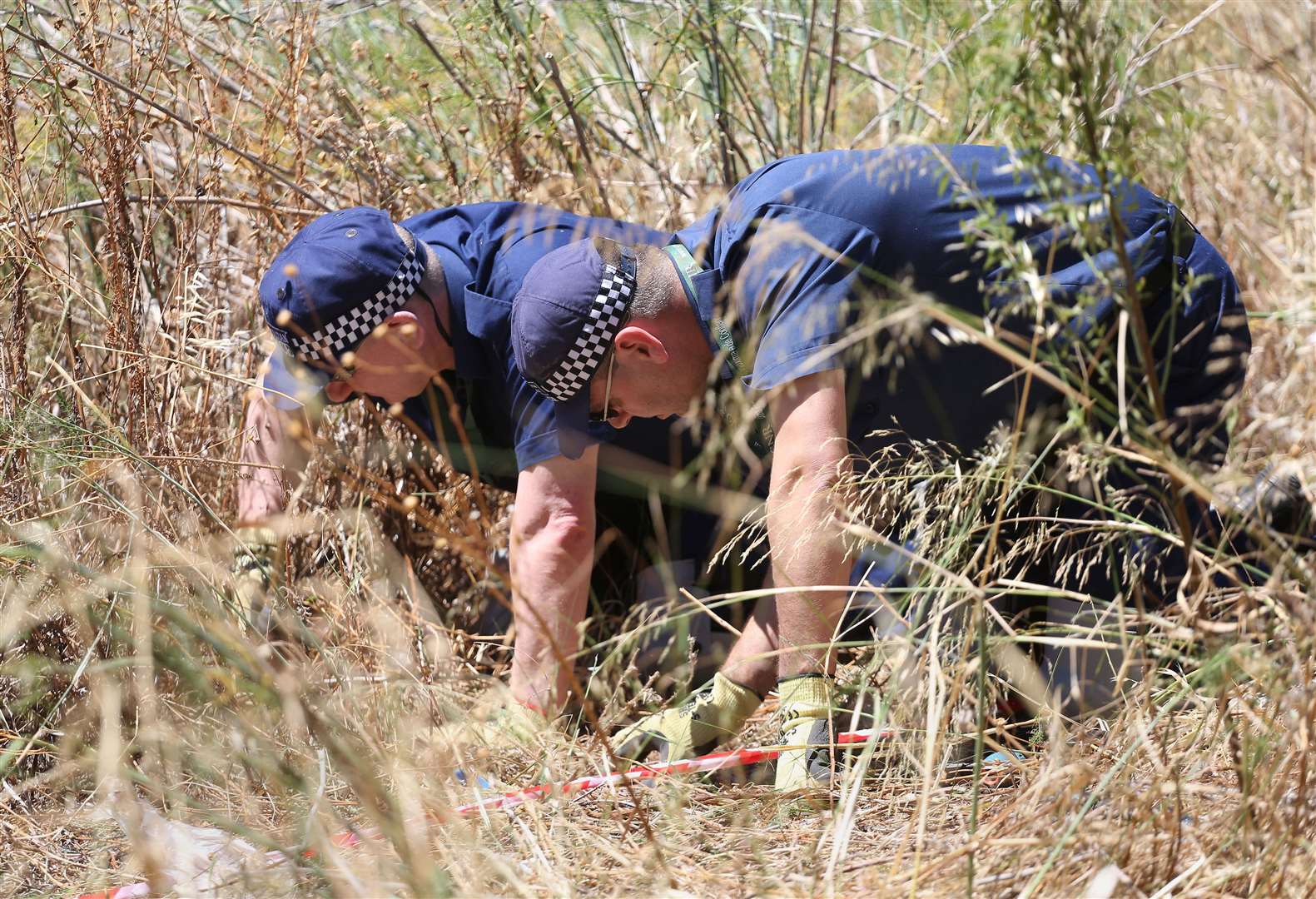 British police conduct a finger-tip search in 2014 of an area of scrubland close to where Madeleine went missing in the resort of Praia da Luz (Philip Toscano/PA)