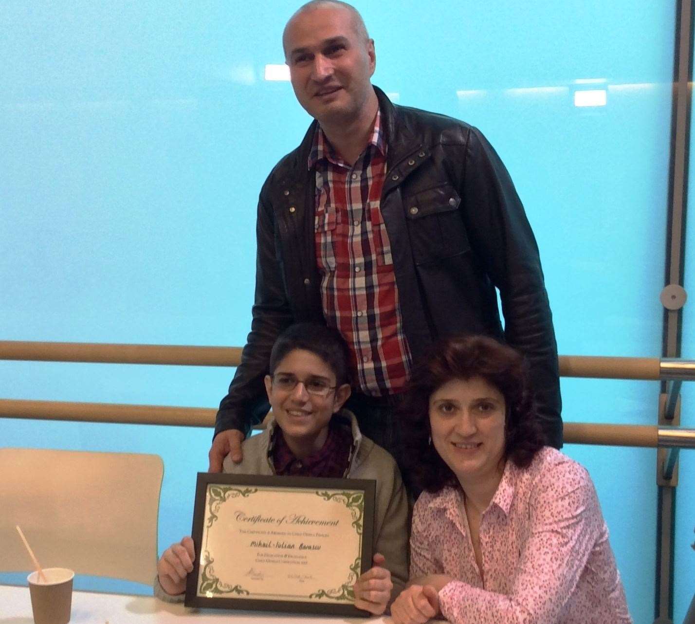 Iulian, aged 12, with dad Gheorghe and mum Gabriela, with certificate for reaching the final of Channel 4's Child Genius show