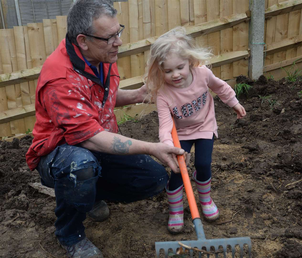 Kelvyn Stewart and granddaughter Scarlett, three, at work on the garden makeover for Tomas Powell's home in Thompson Close, Rainham on Friday. Picture: Chris Davey. (31502704)
