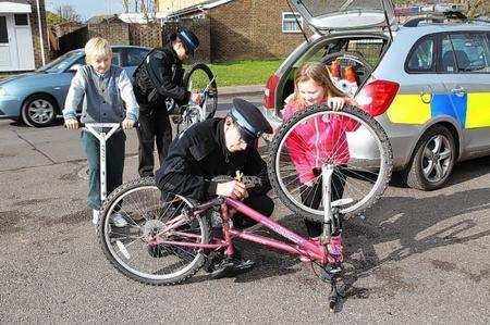 PCSO Ian Henderson marks Courtney Evan's bicycle with an invisible security permanent marker