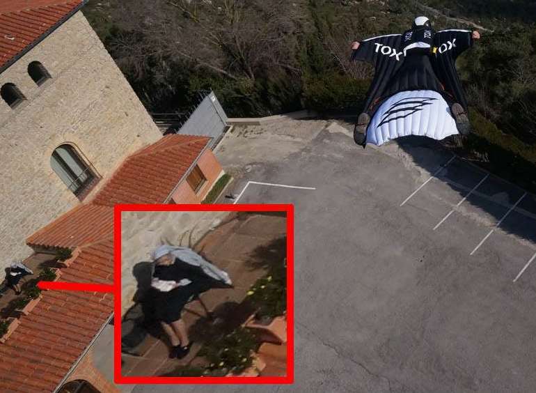 Wingsuit athlete Sam Laming can be seen soaring past a monastery in Spain while an unsuspecting nun reads on the balcony. Picture: Jarno Cordia