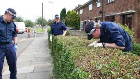 Police officers searching for clues near the bungalow where the bodies were found. Pictures: DAVID HUNT