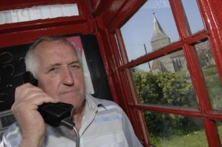 Pub landlord Brian McManus in the phone box residents are fighting to save