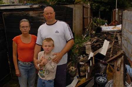 Carron Bowen with neighbour Andy Roberts and Callum Roberts standing by a burnt out shed.