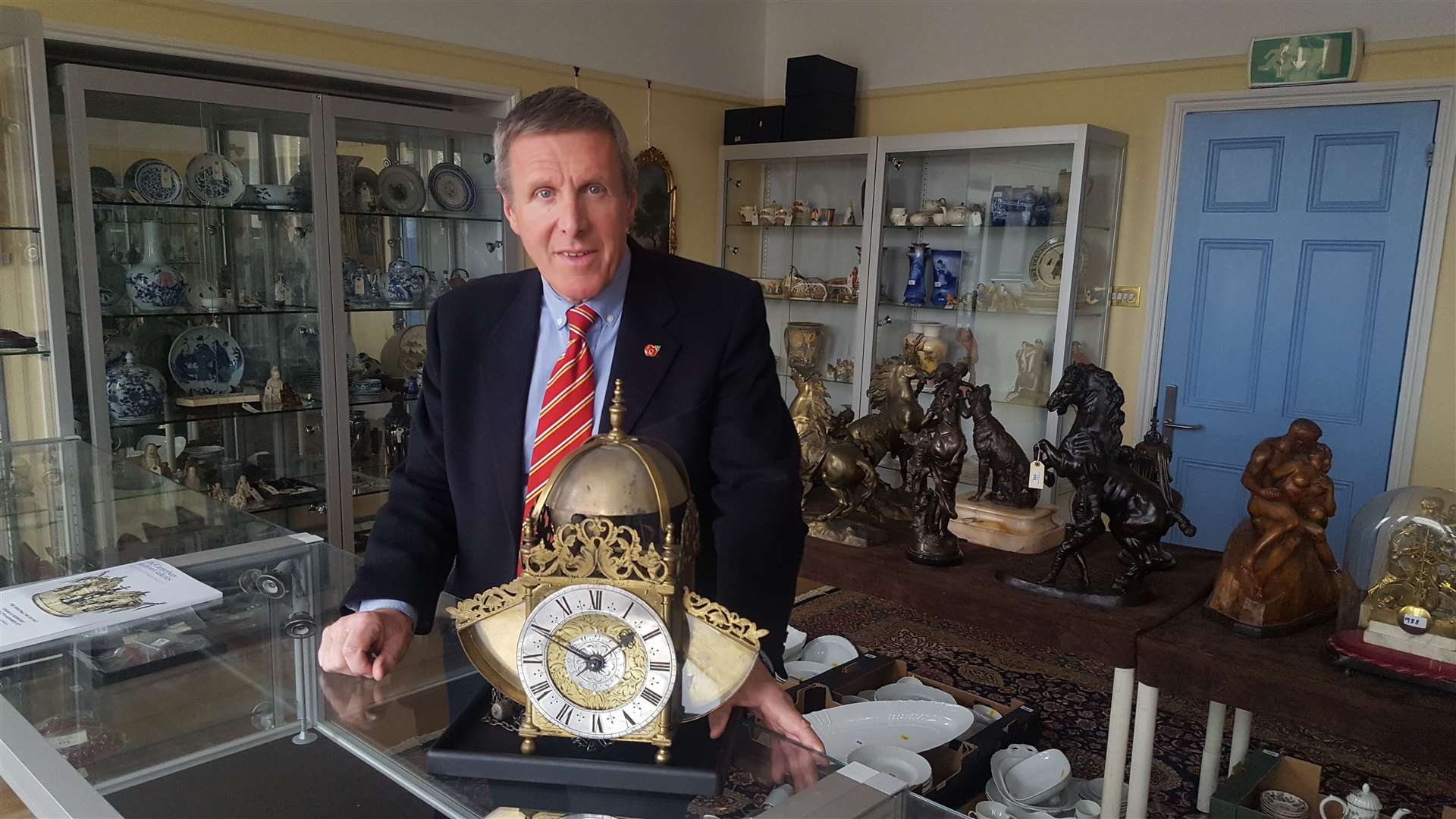 Auctioneer Tony Pratt with a rare Edward East 17th century lantern clock