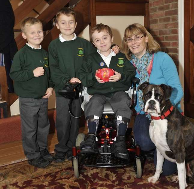 Cameron, holding the piggy bank, with his mum Michelle, brothers Fraser and Alexander and Coco the dog.