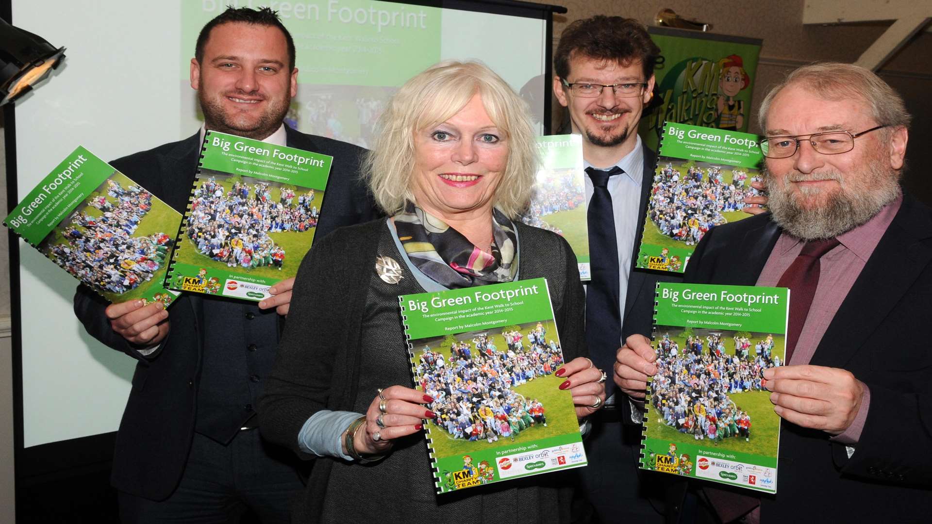 Matt Trusty of Specsavers, Craig Atkins of Orbit South and KM Charity Team trustees Gill Delahunty and Stuart Smith showcase the Big Green Footprint report at the KM Walk to School Awards presentation at Rowhill Grange, Wilmington