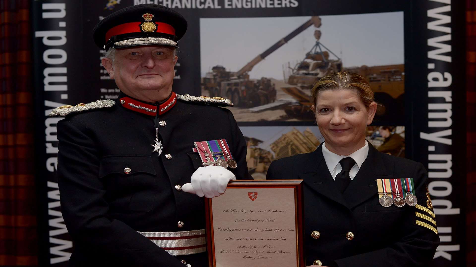 The Lord-Lieutenant of Kent, Viscount De L’Isle MBE presents Petty Officer Lynn Cook with a Certificate for Meritorious Service in recognition of her outstanding loyalty and commitment to the Reserve Forces