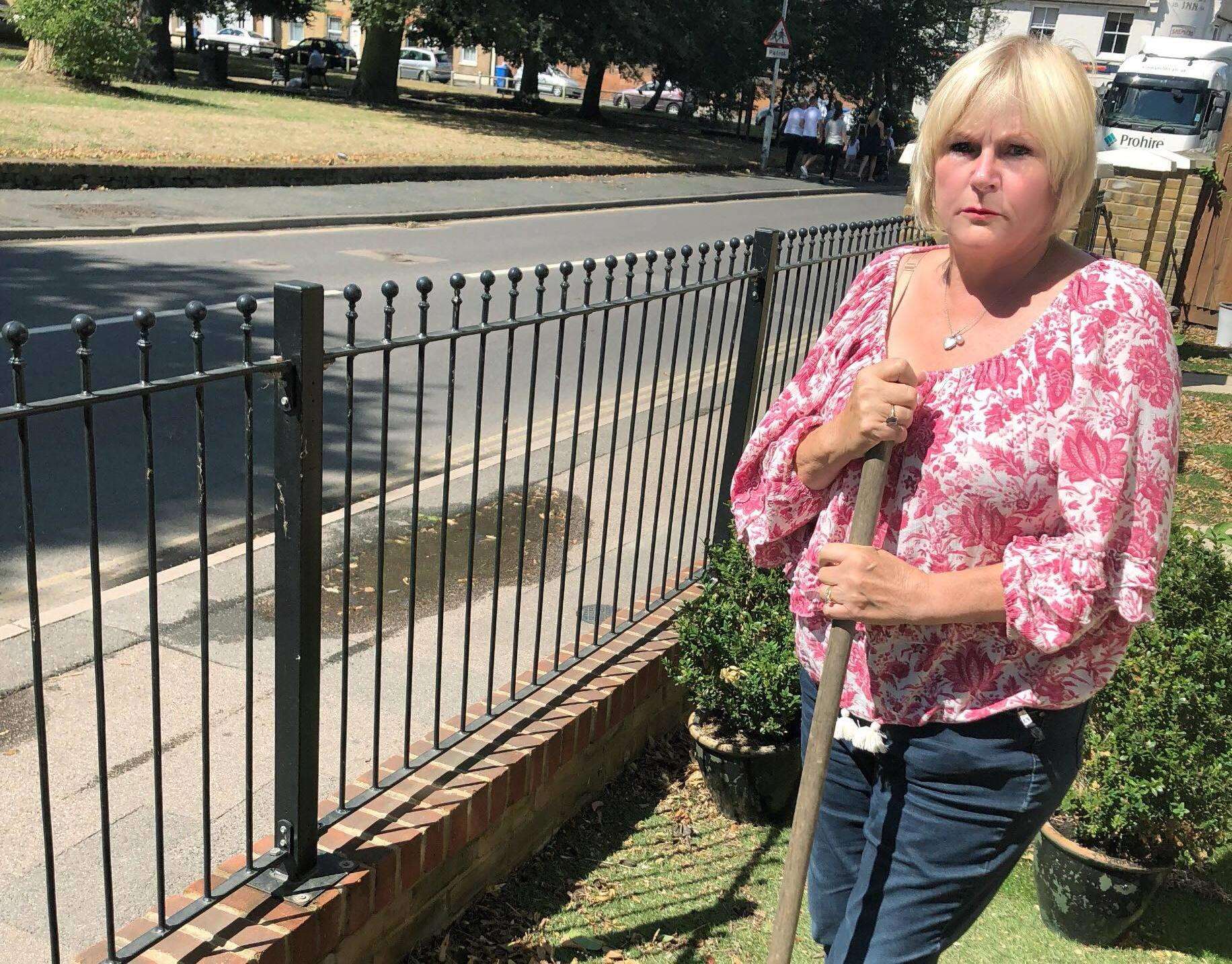Denise Knights clears up after floods outside her home