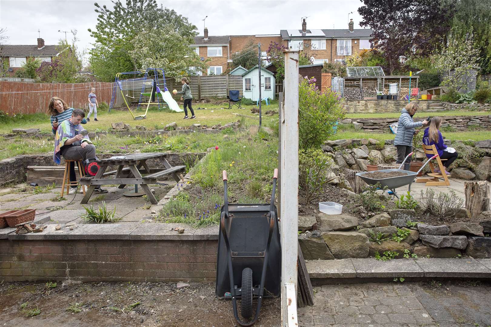 Neighbours in adjacent gardens on Hallamshire Drive, Sheffield, giving haircuts, taken by Historic England photographer Alun Bull (Alun Bull/Historic England/PA)