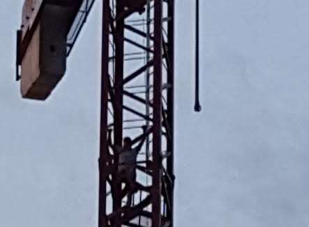 The man scales the crane. Picture: Emma Ransley
