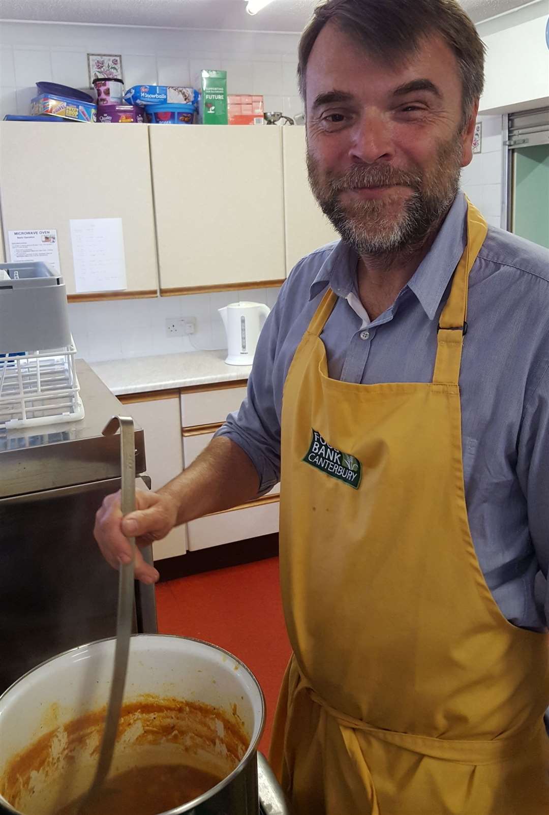 A Food Bank volunteer serving soup (12148201)