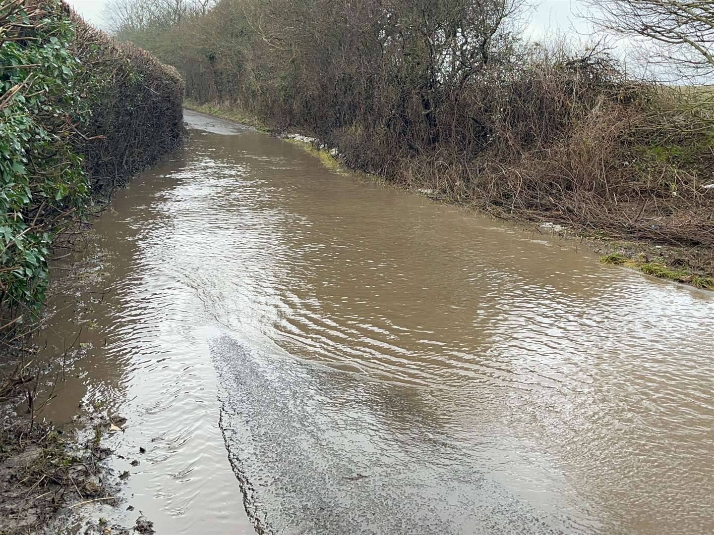 There is a pothole under this surface water but West Hougham residents say anyone unfamiliar with the area would struggle to avoid it